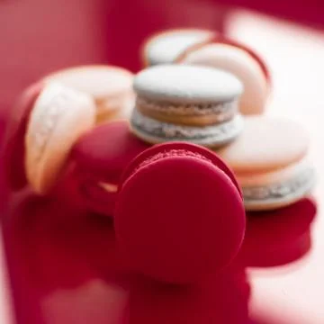 French macaroons on wine red background, parisian chic cafe dessert, sweet fo Stockfoto's
