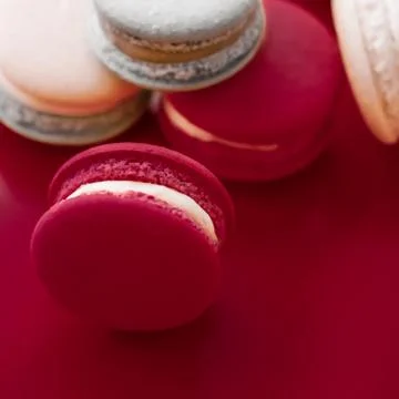 French macaroons on wine red background, parisian chic cafe dessert, sweet fo 스톡 사진