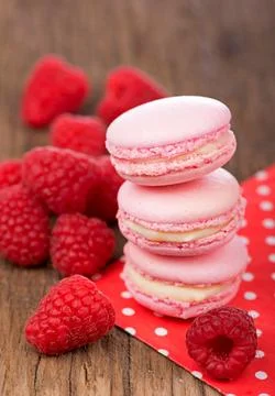 French makarons cake . Pink raspberry macaron cookies on dark wooden boards Stock Photos