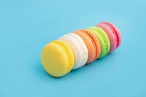 French multicolored macaroons on a blue background. Dessert. Stock Photos
