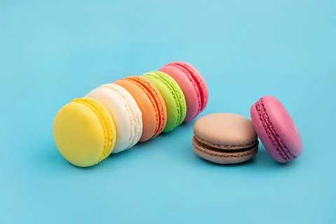 French multicolored macaroons on a blue background. Dessert. Stock Photos