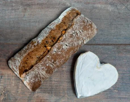 French Neufchatel cheese shaped heart on wooden background Stock Photos