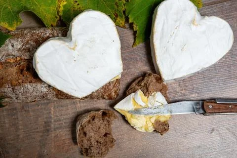 French Neufchatel cheese shaped heart on wooden background Stock Photos