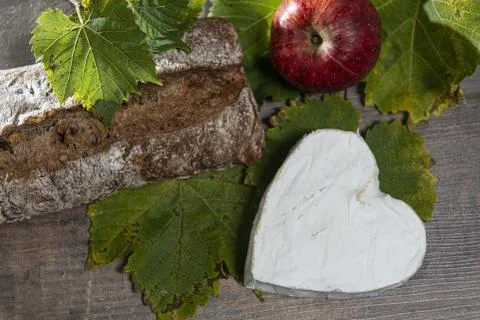 French Neufchatel cheese shaped heart on autumn leaves Stock Photos