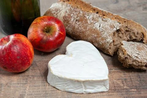 French Neufchatel cheese shaped heart on wooden background Stock Photos