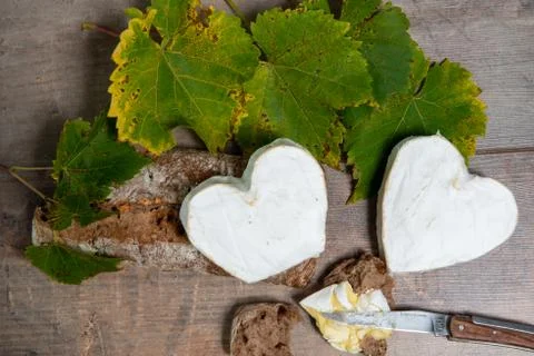 French Neufchatel cheese shaped heart on autumn leaves Stock Photos