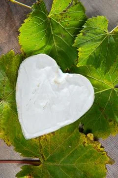 French Neufchatel cheese shaped heart on autumn leaves Stock Photos