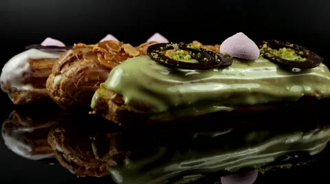 French pastry glazed Eclairs with cream and chocolate, closeup, loop Stock Footage 63853359