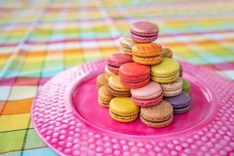 French pastry macarons tower presentation on pink dessert plate at bakery. Retro Stock Photos