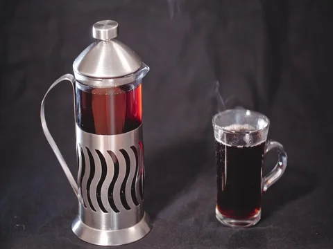 French Press with tea and a transparent Cup of tea on a black background Stock Footage 73809547