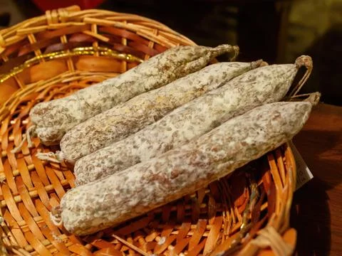 French saucisson sec displayed on wicker basket in a delicatessen Stock Photos
