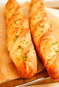 French style bread with wrapped paper on wooden board Stock Photos
