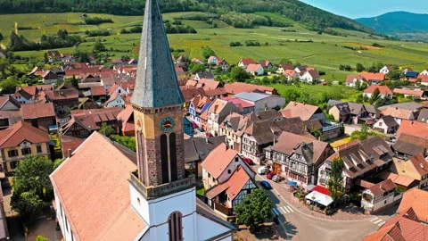 French-style cathedra with a clock and colourful houses in Kintzheim, France. Stock Footage 274304903