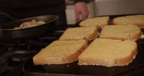 French toast being prepared on flat top griddle in kitchen for breakfast Video stock 123734997