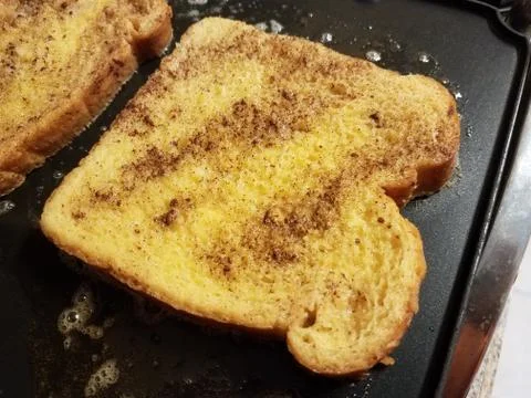 French toast bread with egg and cinnamon cooking on grill Stock Photos