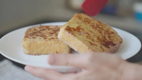 French toast is placed on white plate, showing two browned bread slices Stock-Footage 343318501