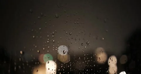 Frequent lightning flashes illuminate water drops on window glass during storm Stock Footage 345026780