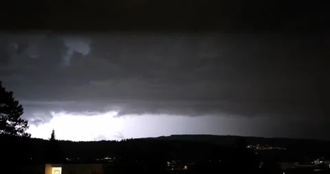 Frequent lightning flashes over a hillside village and residential area at night Stock Footage 345026834