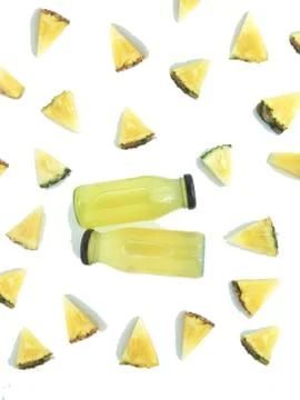 Fresh and cold pineapple drink among triangular piece of pineapple Stock Photos