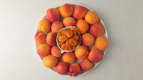 Fresh and dried apricots rotating on a white plate Stock Footage 341822093