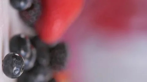 A fresh and vibrant vertical composition of mixed red and black berries spilling Stock Footage 280983130