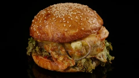 Fresh appetizing hamburger rotating on black background. Seamless loopable shot Stock Footage 73481499