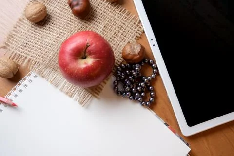 Fresh apple and notebook create cozy study scene on wooden table 库存照片