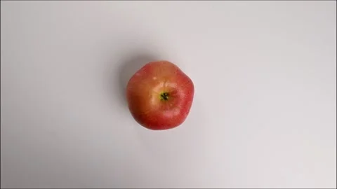 Fresh apple quickly taken from the table in dynamic close-up motion Stockbeeldmateriaal 305662993