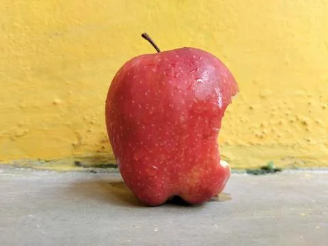 Fresh apple with a visible bite mark on the side, symbolizing taste, freshness,  Stock Photos