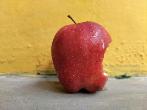 Fresh apple with a visible bite mark on the side, symbolizing taste, freshness Stock Photos