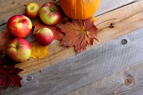 Fresh Apples, Pumpkins, and Maple Leaves Border Wood Background Stock Photos