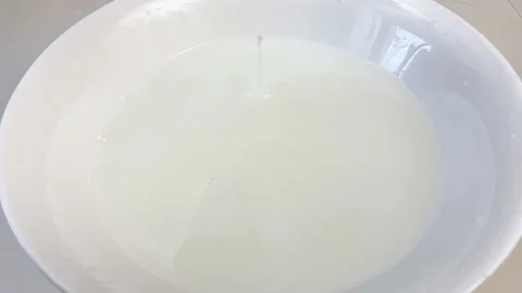 Fresh apricots fall down in plate with milk, closeup, super slow motion Stock Footage 132782483