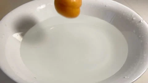 Fresh apricots fall down in plate with water, closeup, super slow motion Stock Footage 135756314