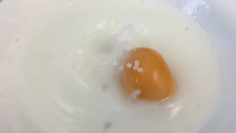 Fresh apricots fall down in plate with milk, closeup, super slow motion Stock Footage 148389493