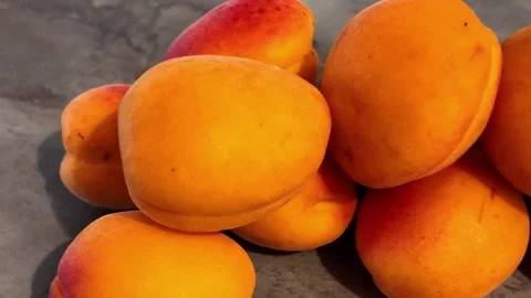 Fresh apricots rotating in deep plate on white background Видео 342982632