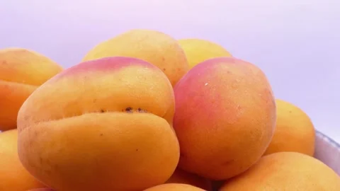 Fresh apricots rotating in deep plate on white background Vídeos de archivo 342982721