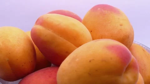Fresh apricots rotating in deep plate on white background 動画素材 342982734