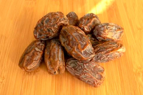 Fresh arabic dates isolated on light wooden table. Date palm fruit. Stock Photos