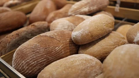 Fresh artisan bread loaves with rustic crusts in supermarket bakery display Stock Footage 345358938