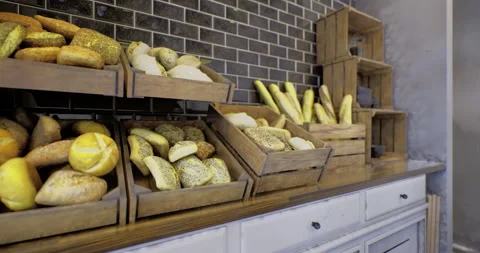 Fresh artisanal bread displayed in rustic wooden crates at local bakery Stock Footage 326409896