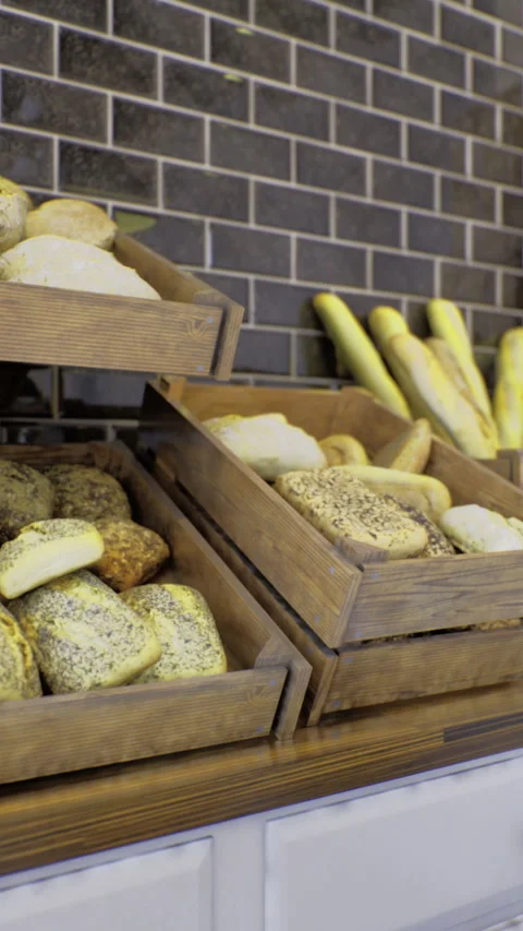 Fresh artisanal bread displayed in rustic wooden crates at local bakery Stock Footage 329175081