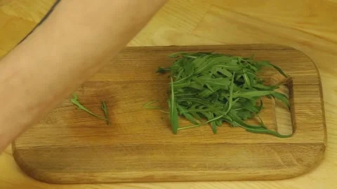 Fresh arugula is cut with a sharp knife Stock Footage 192089440