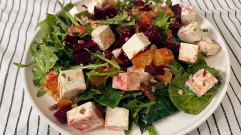 Fresh arugula salad with boiled beetroot, crumbled feta cheese, orange slices Video stock 302971111