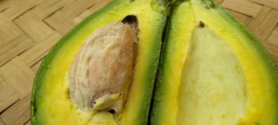 Fresh Avocado Split Halves On Bamboo Mat Stock Photos