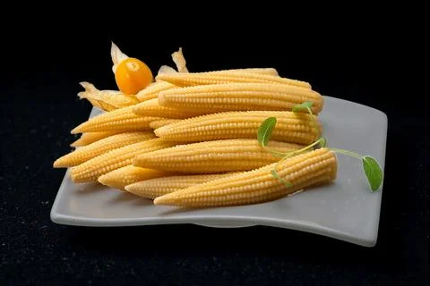 Fresh baby corn stacked on a rectangular plate Stock Photos