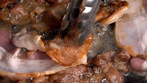 Fresh bacon added to sizzling pan closeup macro Stock Footage 111118062