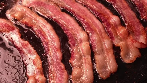 Fresh Bacon slices being cooked in a frying pan. Bacon strips sizzling. 스톡 동영상 334641675