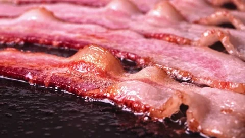 Fresh Bacon slices being cooked in a frying pan. Bacon strips sizzling. 스톡 동영상 334641683