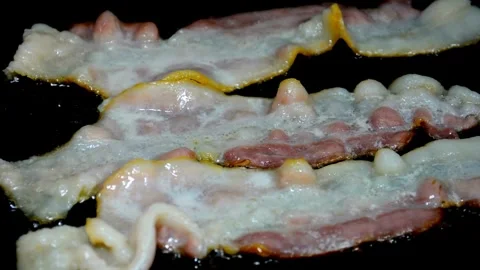 Fresh Bacon slices being cooked in a frying pan. Bacon strips sizzling. 스톡 동영상 334641721