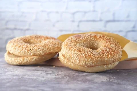 Fresh bagel bread in a paper on table 스톡 사진